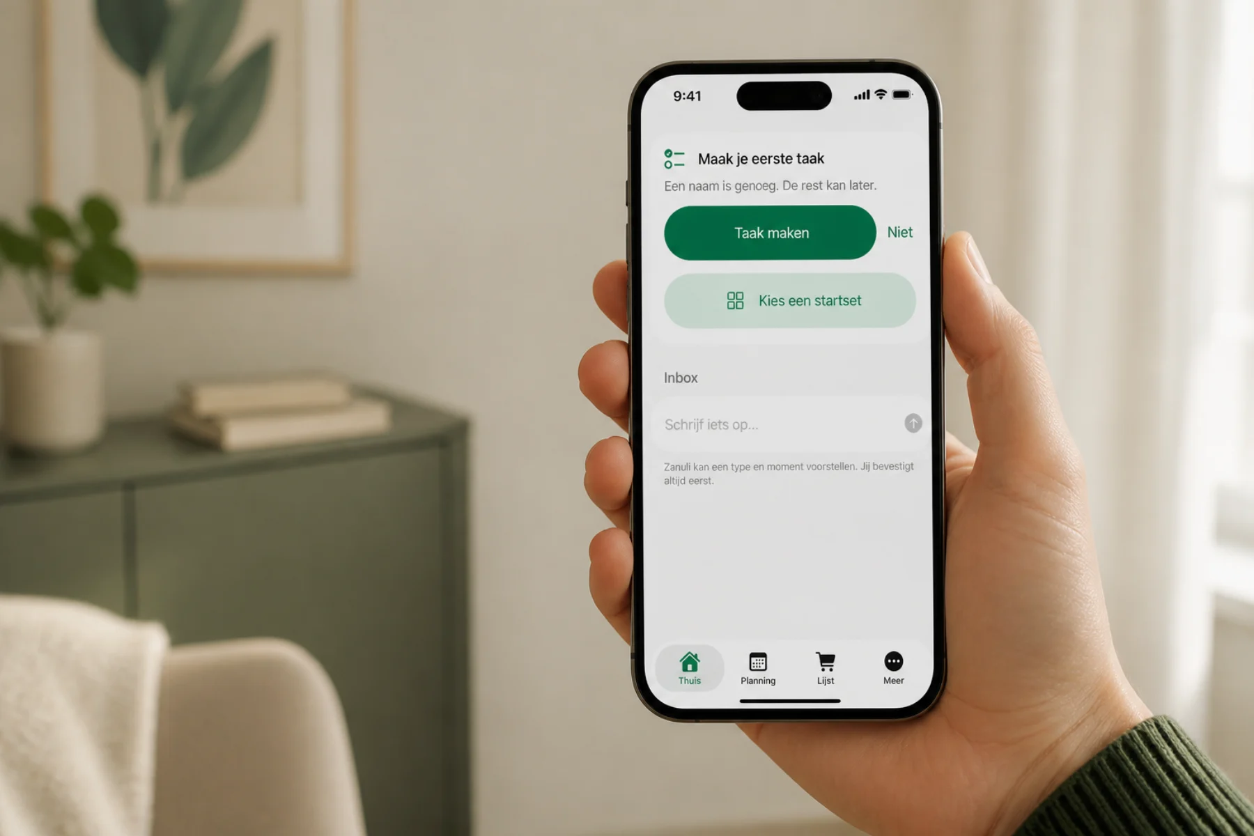 Een hand houdt thuis een telefoon vast waarop het rustige Zanuli-overzicht zichtbaar is.